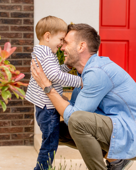 Father and son in front of house