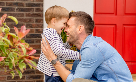 Father and son in front of house