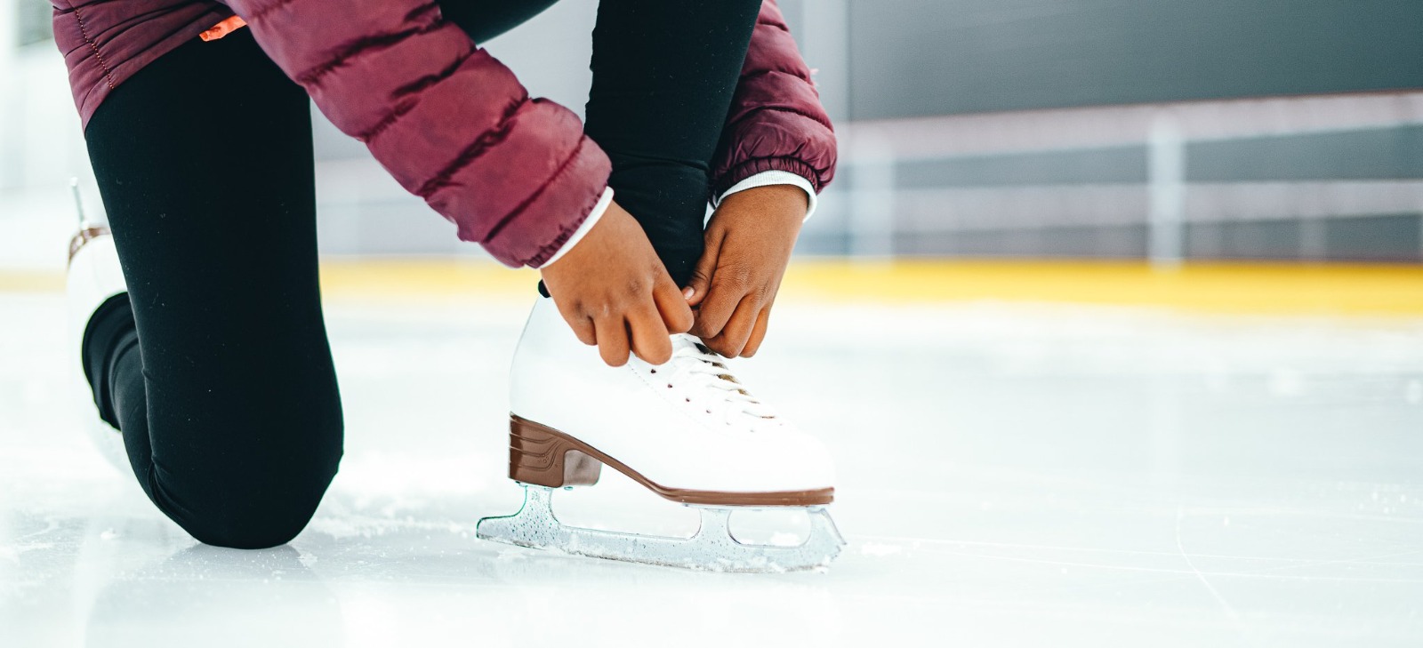 Girl lacing up her skate at the UNIplex